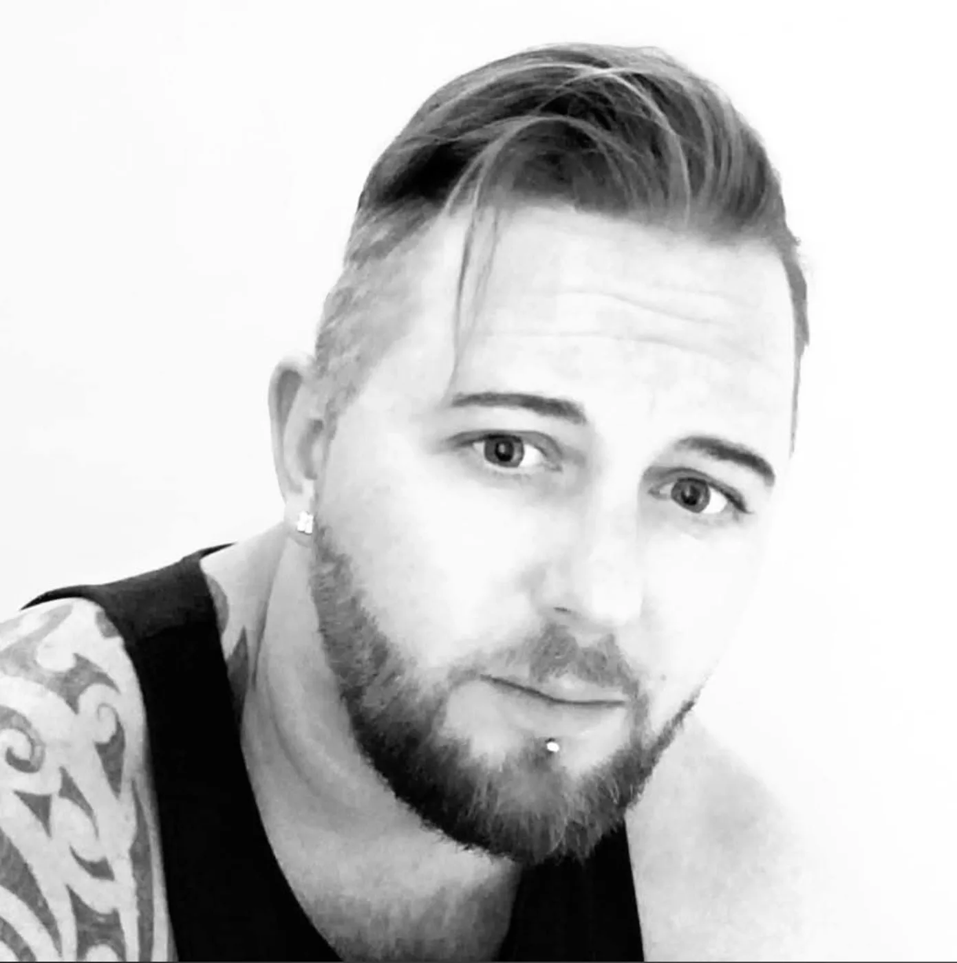 Black and white portrait of Lee Knight, bearded, with short swept-back hair